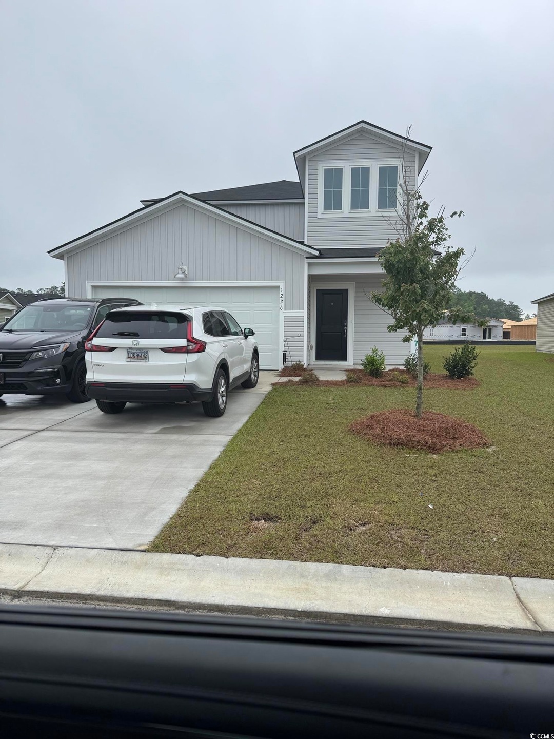 Traditional-style house featuring concrete drivewa