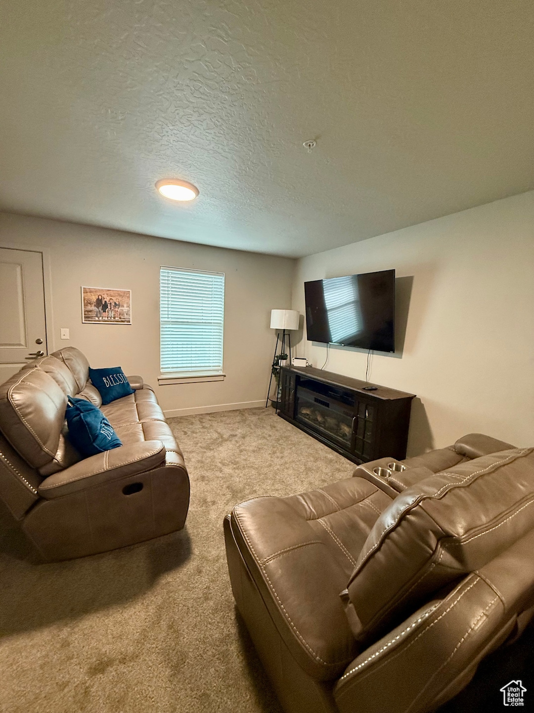 Carpeted living area with a textured ceiling