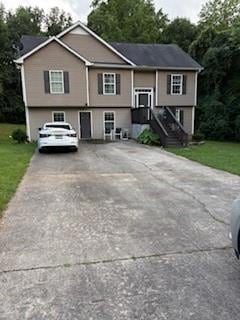 Bi-level home with a front lawn and concrete driveway