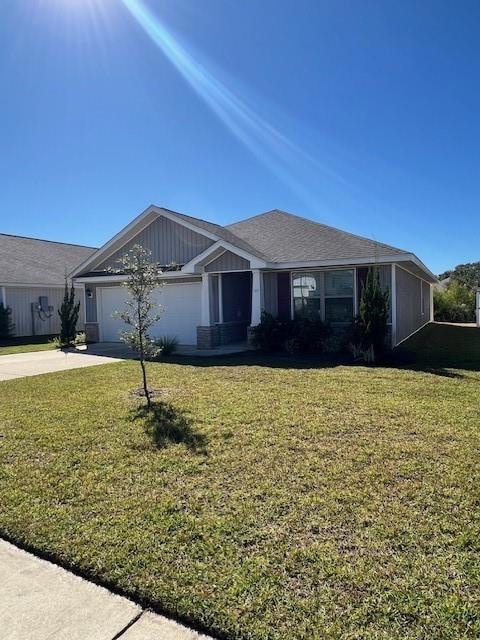 View of front of property featuring driveway, a front lawn, and an attached garage
