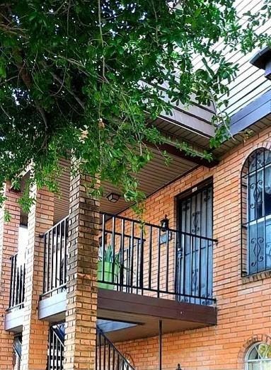 View of side of property with a balcony and brick siding