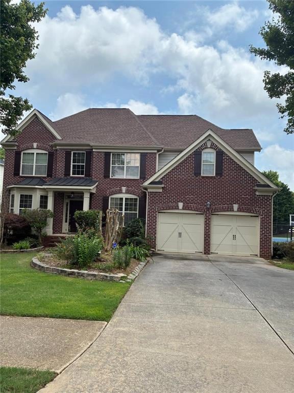 View of front of home with concrete driveway, brick siding, roof with shingles, a garage, and a front lawn