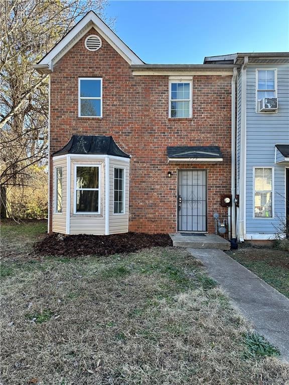 View of front of property featuring brick siding and a front yard