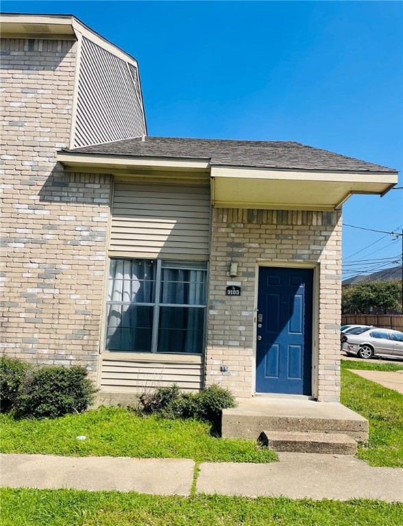 Entrance to property featuring brick siding and a
