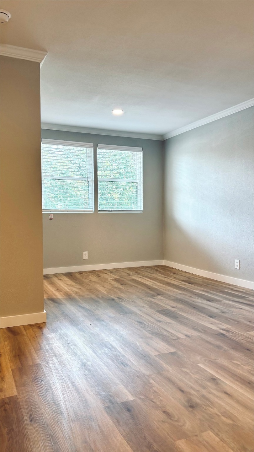 Unfurnished room with crown molding and wood finished floors