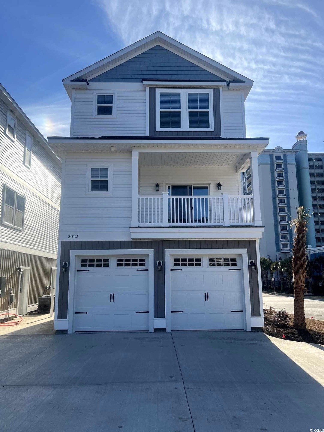 View of front property with a balcony and a garage