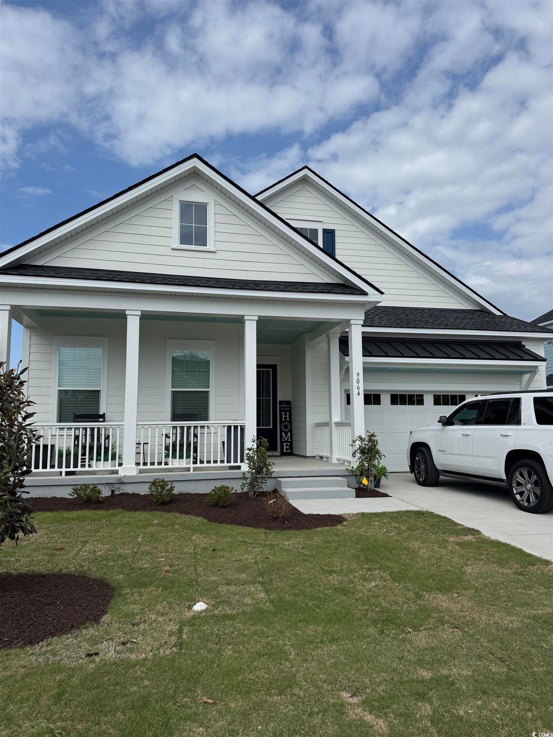 View of front of home with a front yard, an attach