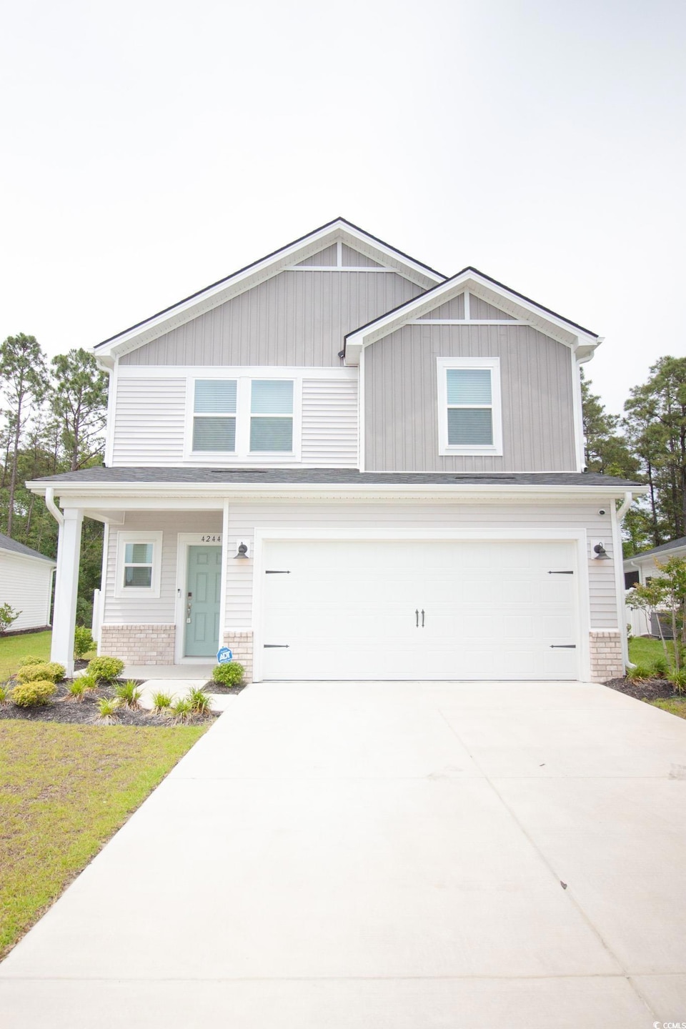 View of front of home featuring a garage, driveway, and brick siding