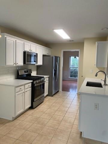 Kitchen featuring white cabinetry, stone counterto