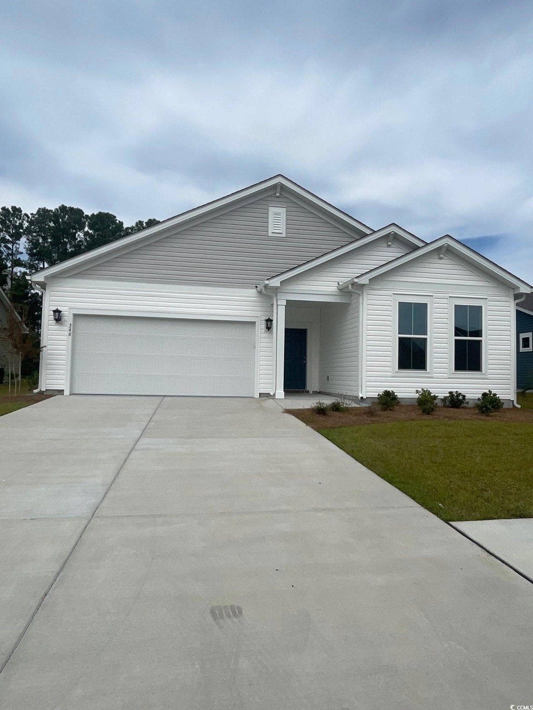 Single story home with a garage and a front lawn