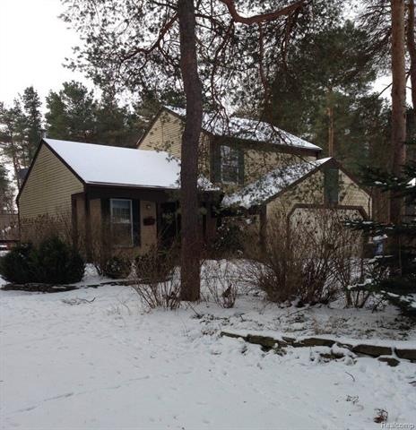 323 Maple Knoll Dr front view with wooded setting.