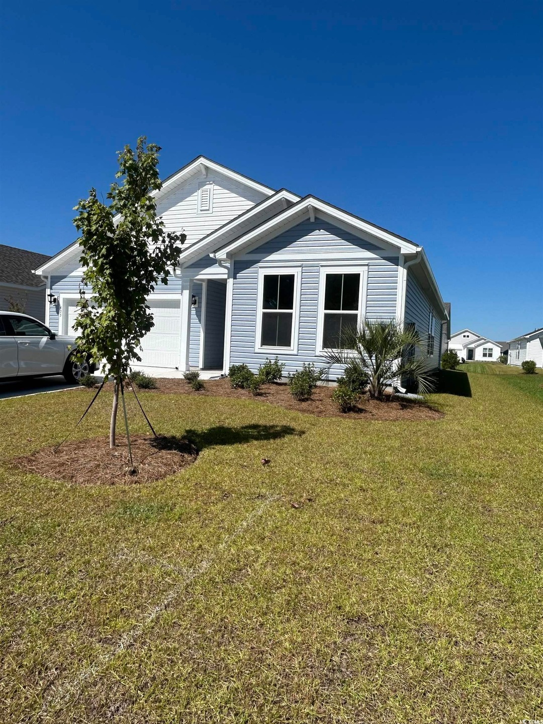View of front of home with a front lawn and a garage