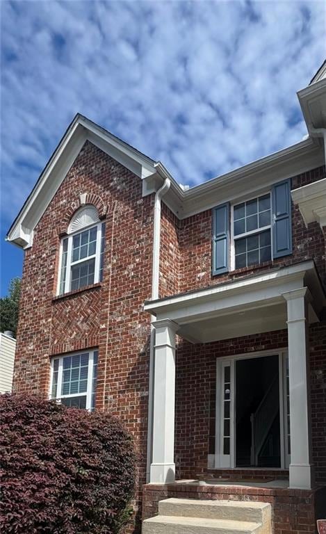 View of front facade featuring brick siding and a porch