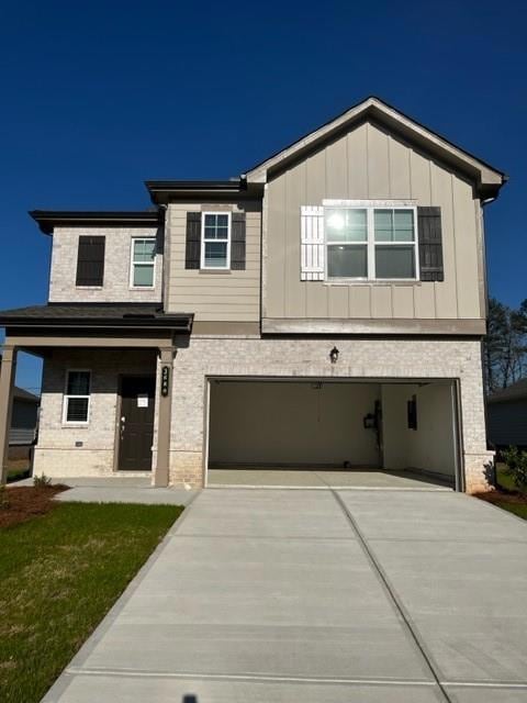 View of front facade featuring an attached garage, brick siding, and driveway