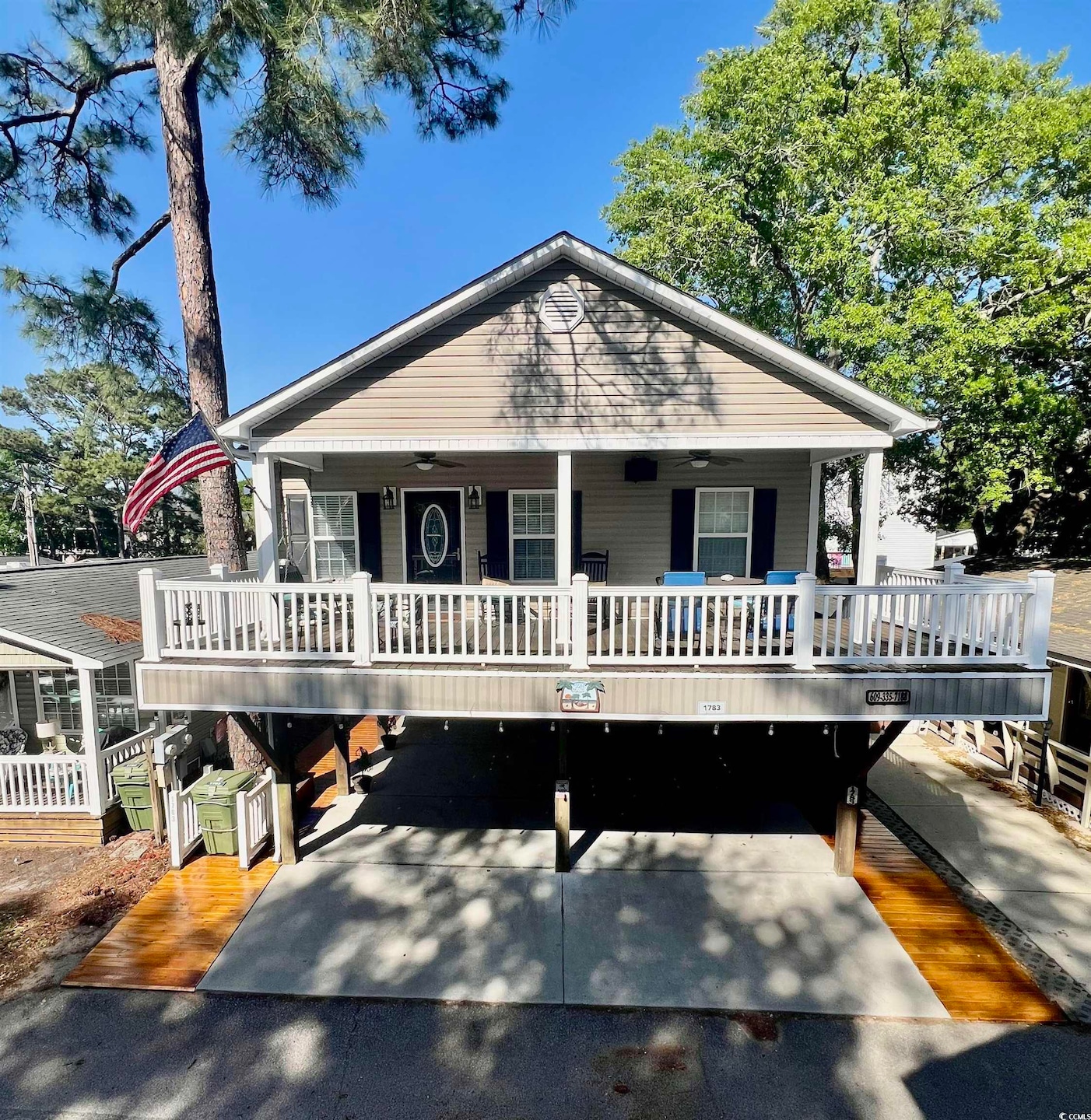 Bungalow featuring aphalt driveway, a porch, and a