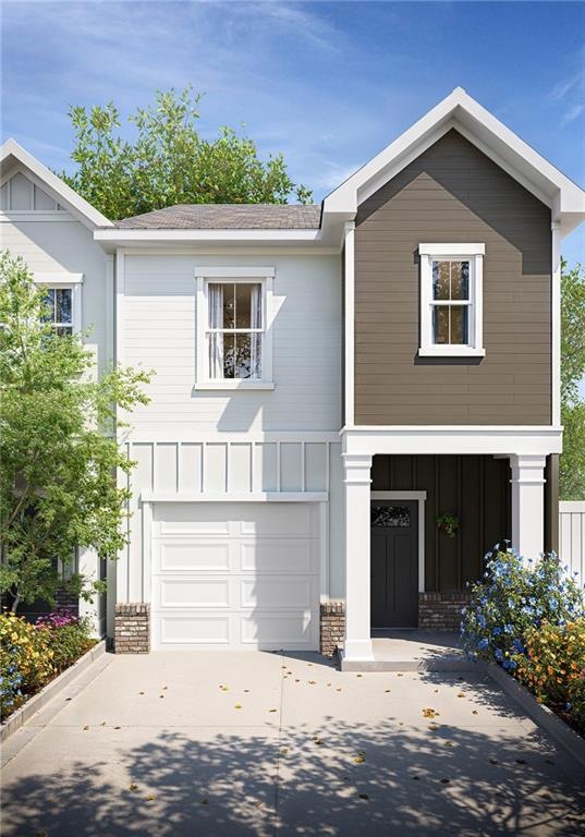 View of front of property featuring driveway, an attached garage, stone siding, and board and batten siding