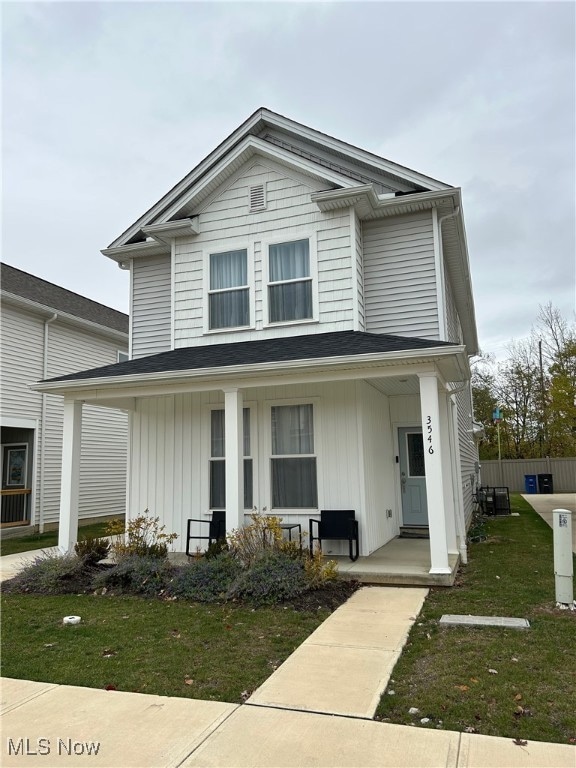 View of front of house with a porch, a front yard, and board and batten siding