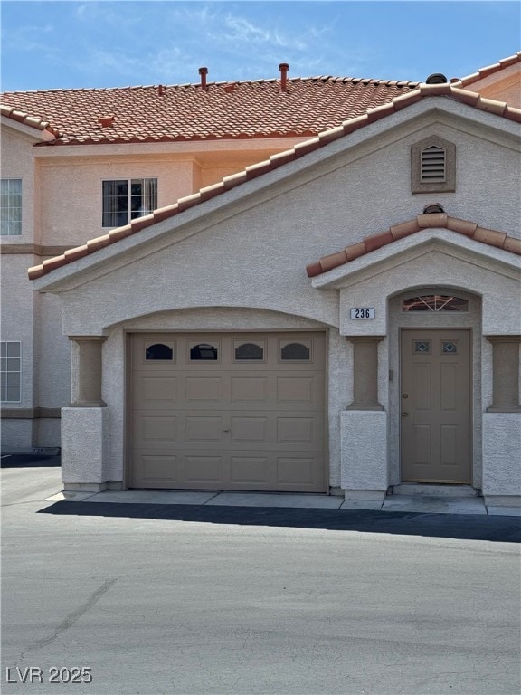 View of front of house with stucco siding and a ti