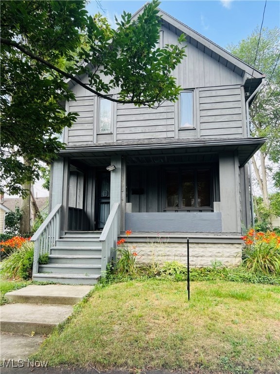 View of front of house with a front yard and covered porch