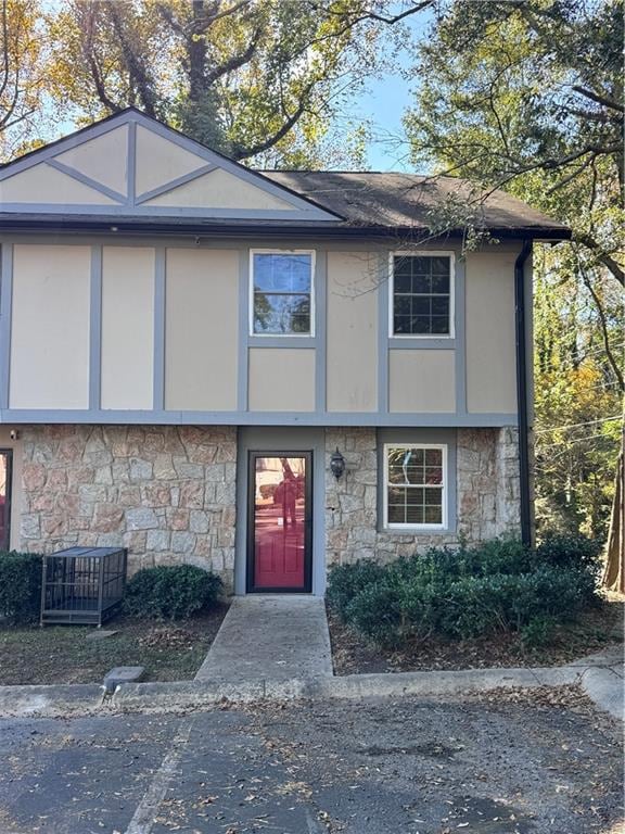 View of front of home featuring stone siding and stucco siding