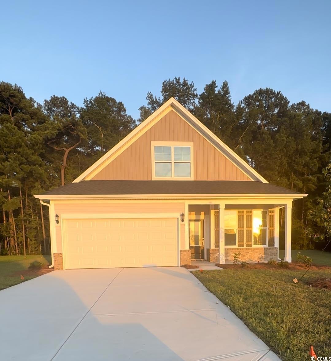 View of front facade with a yard, covered porch, a