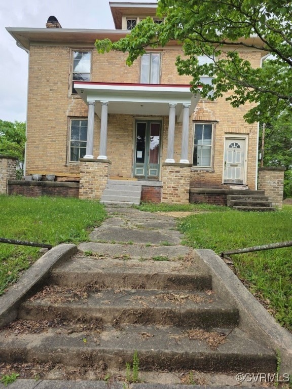 View of exterior entry with brick siding and a por