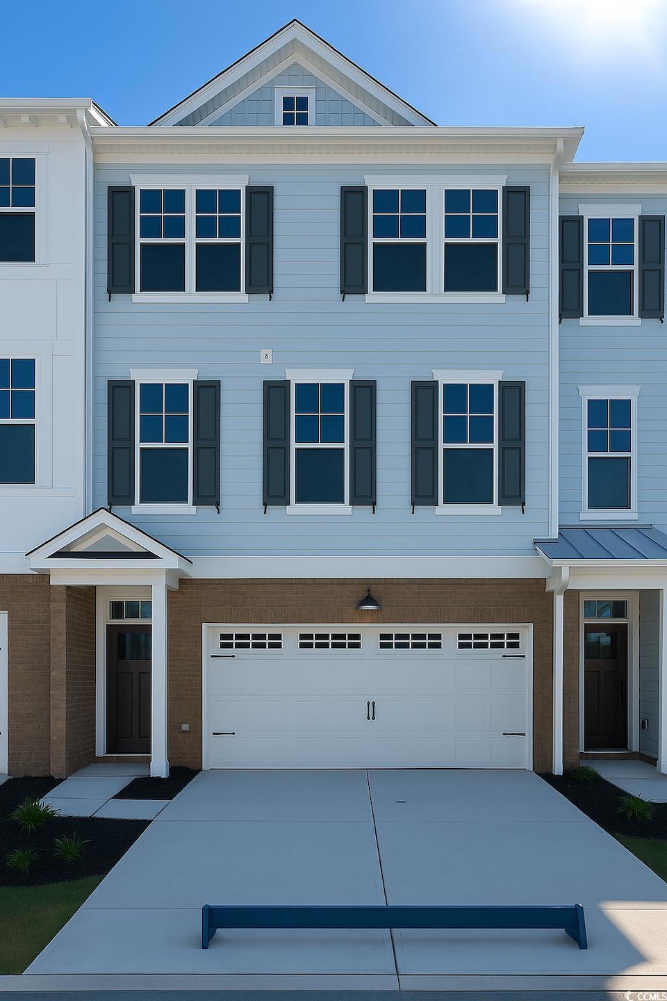 View of front of home featuring concrete driveway, a garage, and brick siding