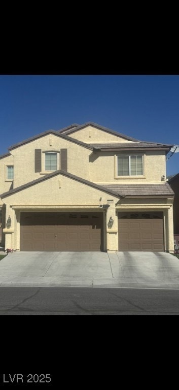 Traditional home with stucco siding, concrete driveway, and an attached garage