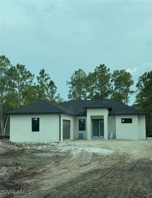Back of property featuring a shingled roof