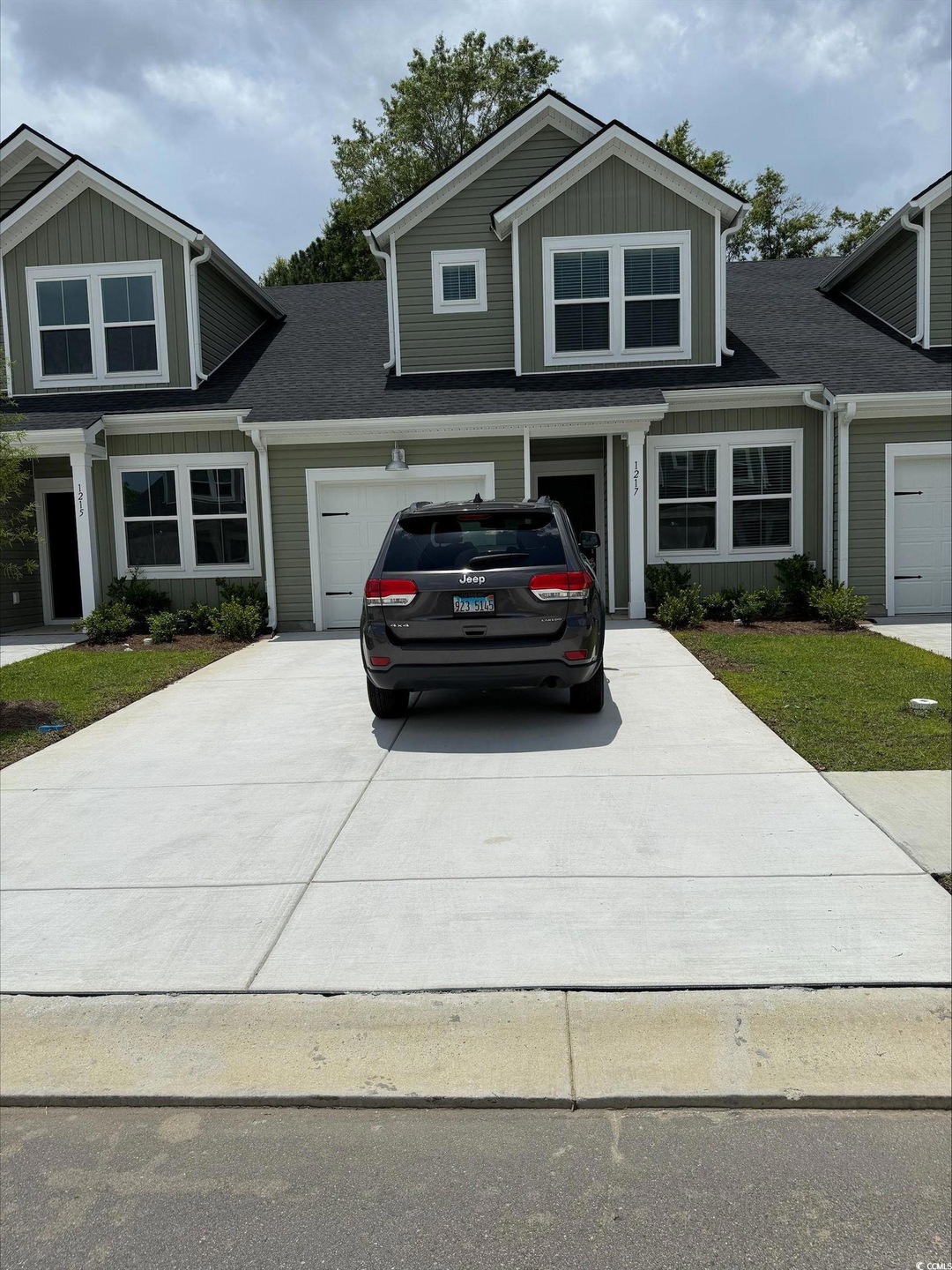 View of front of property featuring driveway, board and batten siding, a garage, and roof with shingles