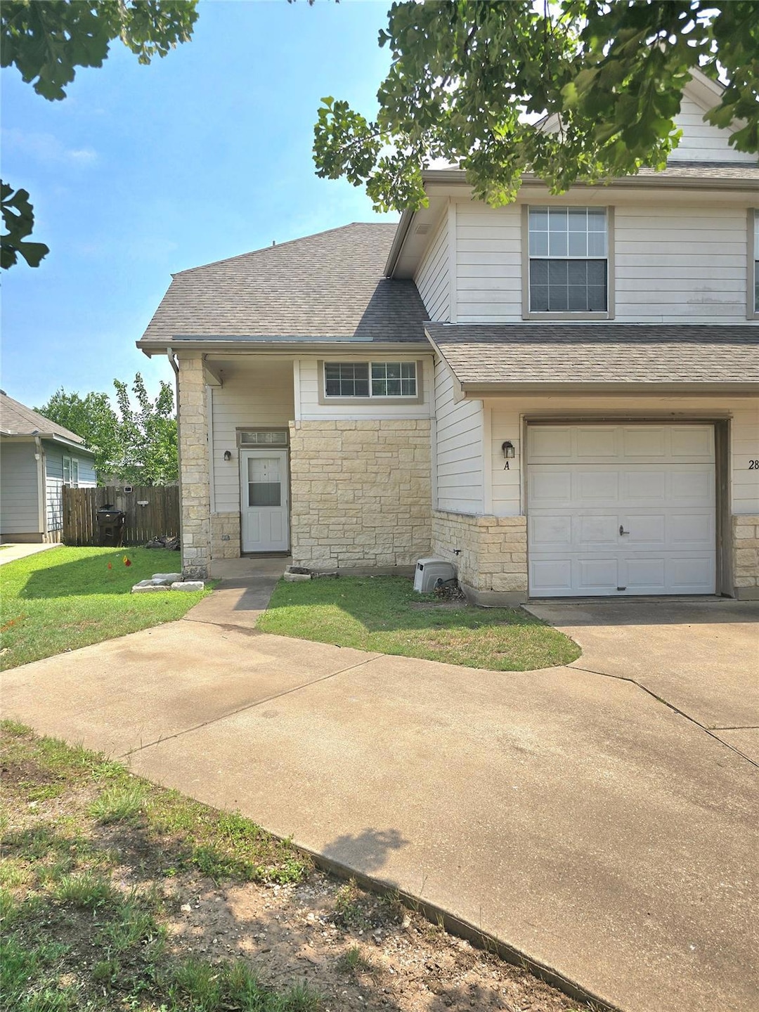 View of front facade featuring stone siding, a ga