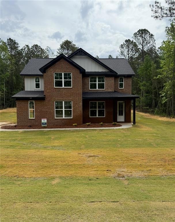 Rear view of house featuring a yard, board and bat