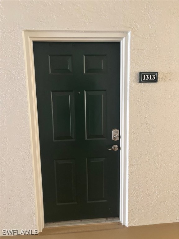 Doorway to property with stucco siding