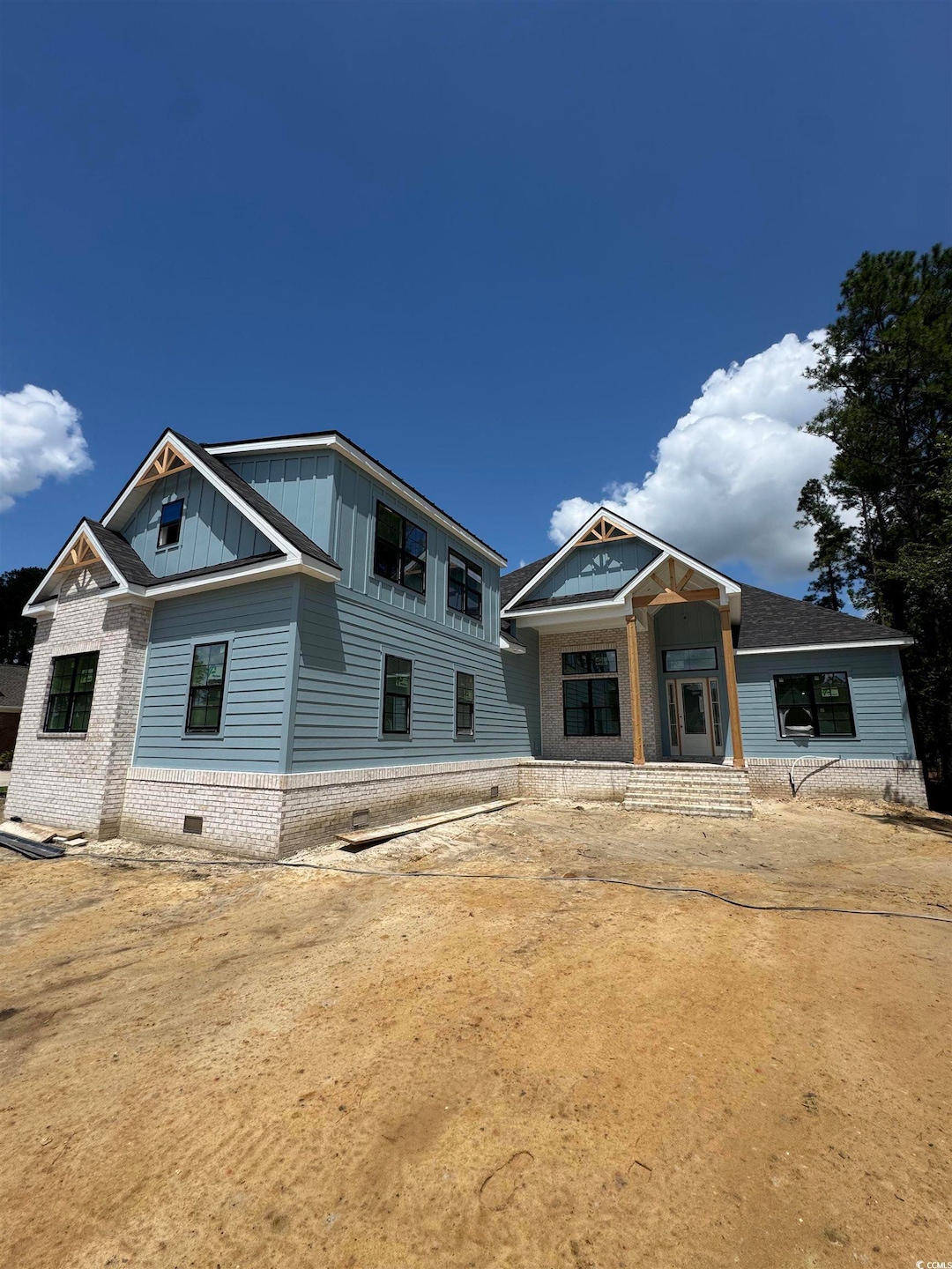 View of front facade with board and batten siding and brick siding