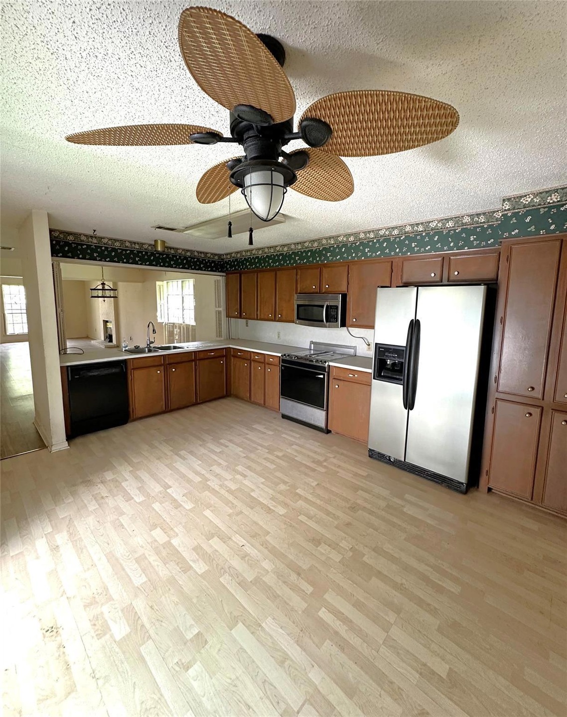 Kitchen with light wood-type flooring, a textured 