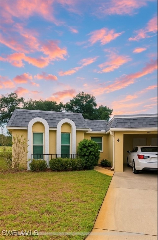 View of front of home with a lawn, stucco siding,