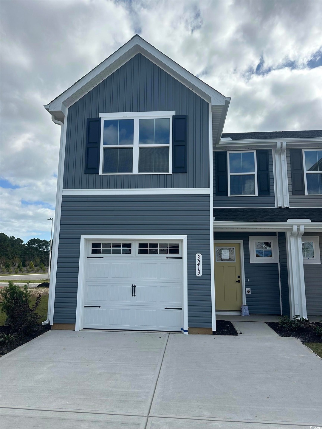 View of front of home with an attached garage, driveway, and board and batten siding