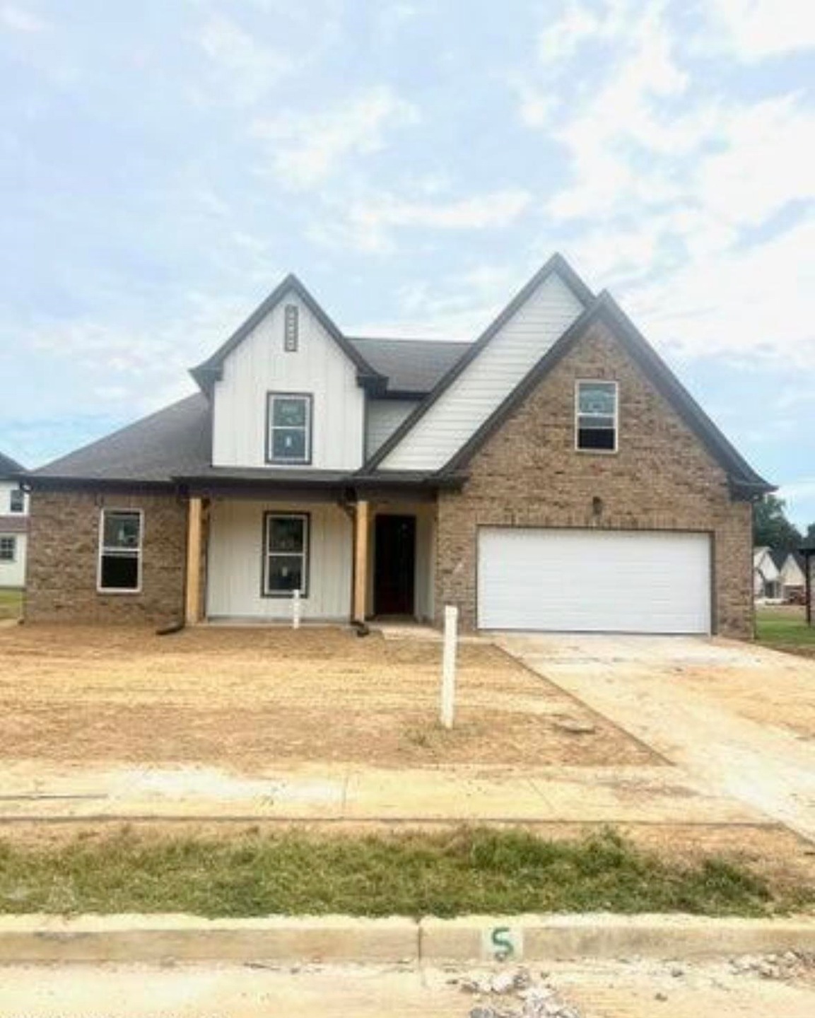 View of front of house featuring driveway, a garage, and board and batten siding