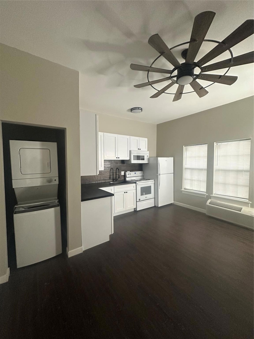 Kitchen with dark wood-type flooring, range, fridg
