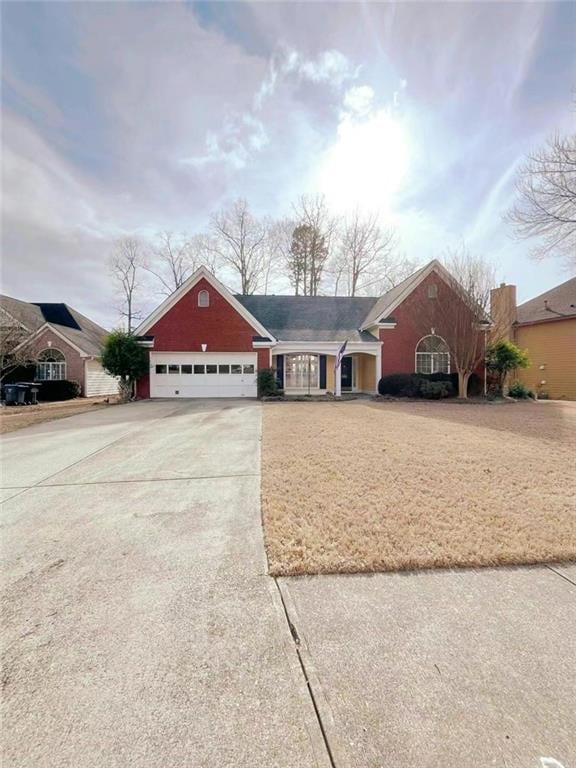 View of front facade featuring a garage, brick sid