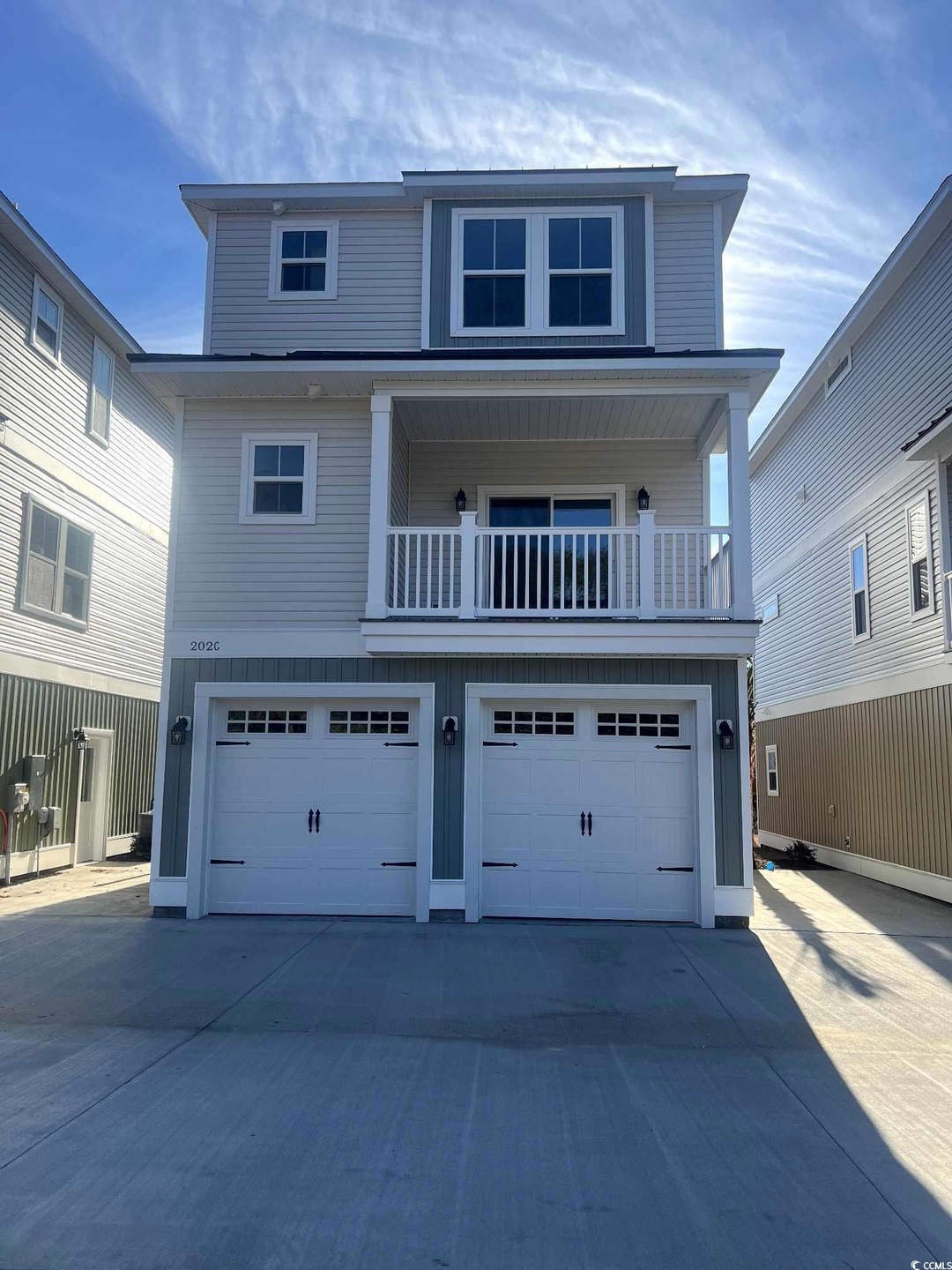 View of front of property with a balcony and a gar