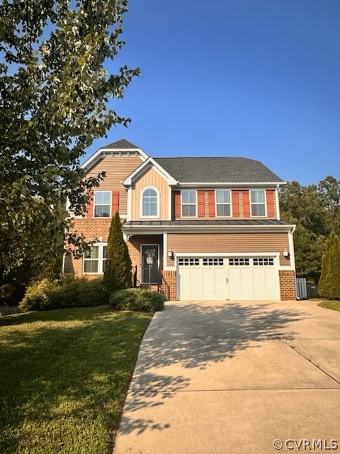 View of front facade with a garage and a front lawn