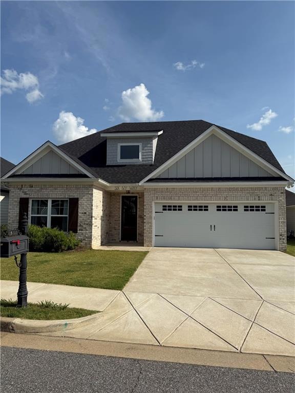 View of front facade featuring brick siding, a shingled roof, driveway, a garage, and a front yard