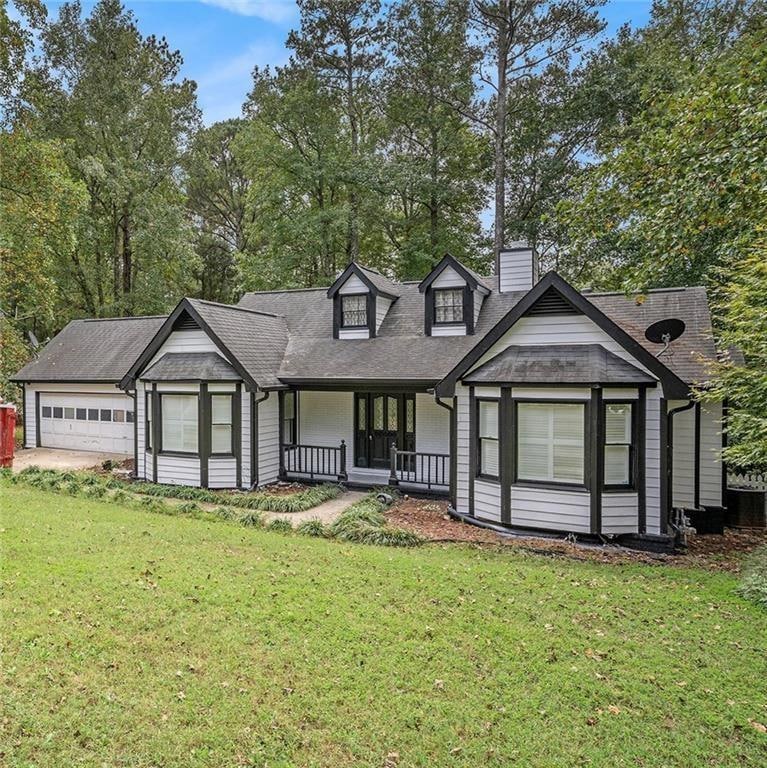 View of front of property with a garage, a porch, 