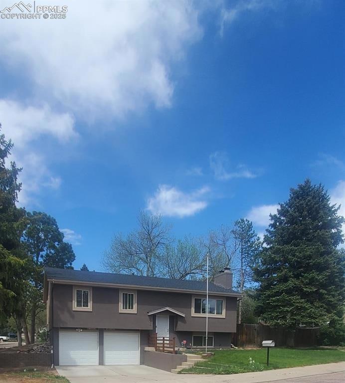 Bi-level home with stucco siding, an attached gara