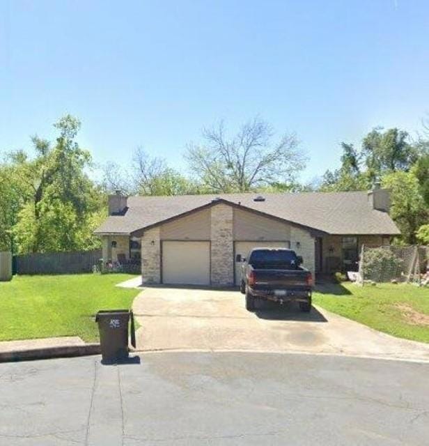 View of front of property with a garage and concr