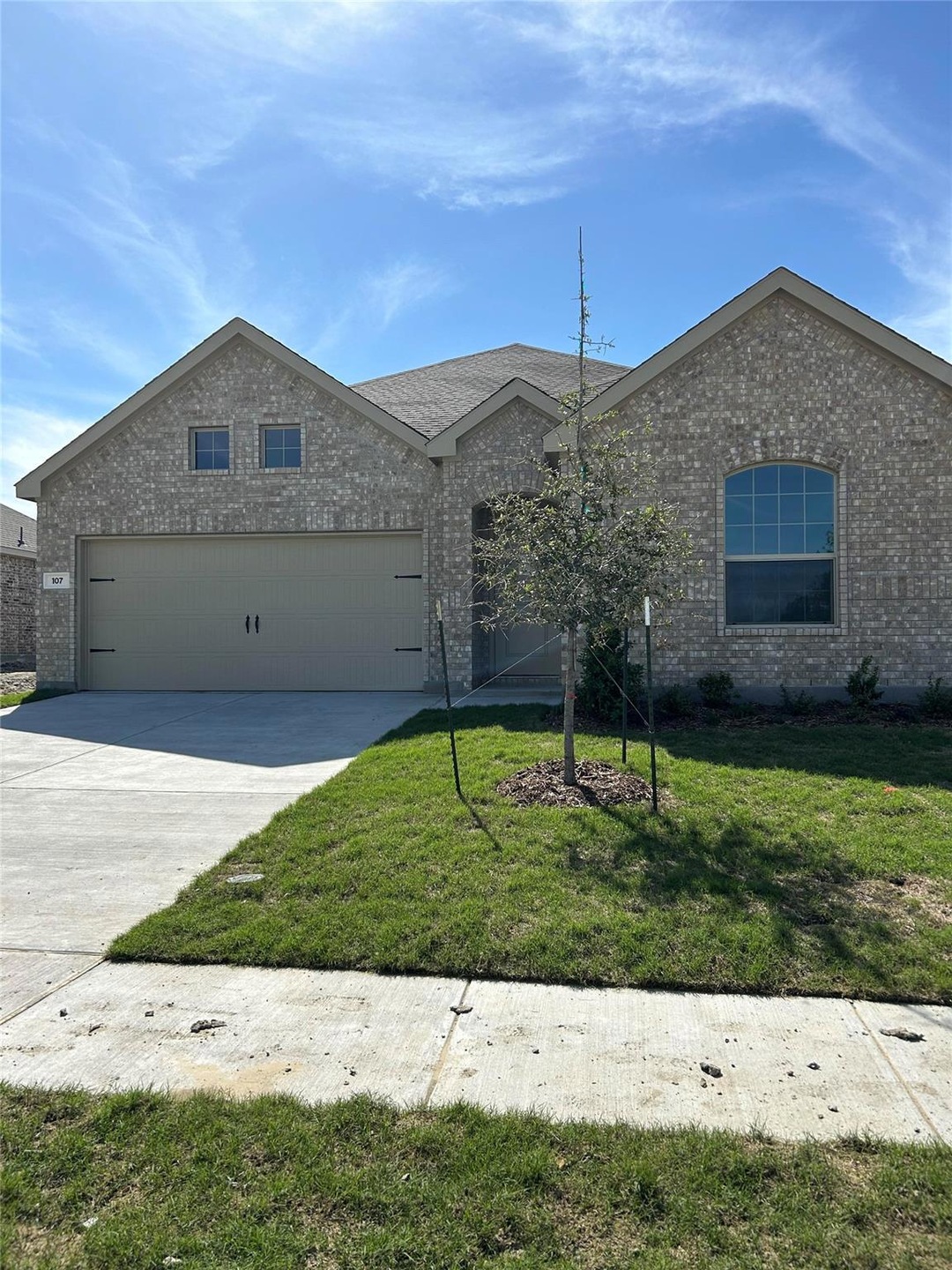 View of front of house featuring a front lawn and a garage
