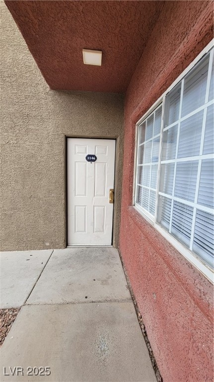 View of exterior entry featuring stucco siding