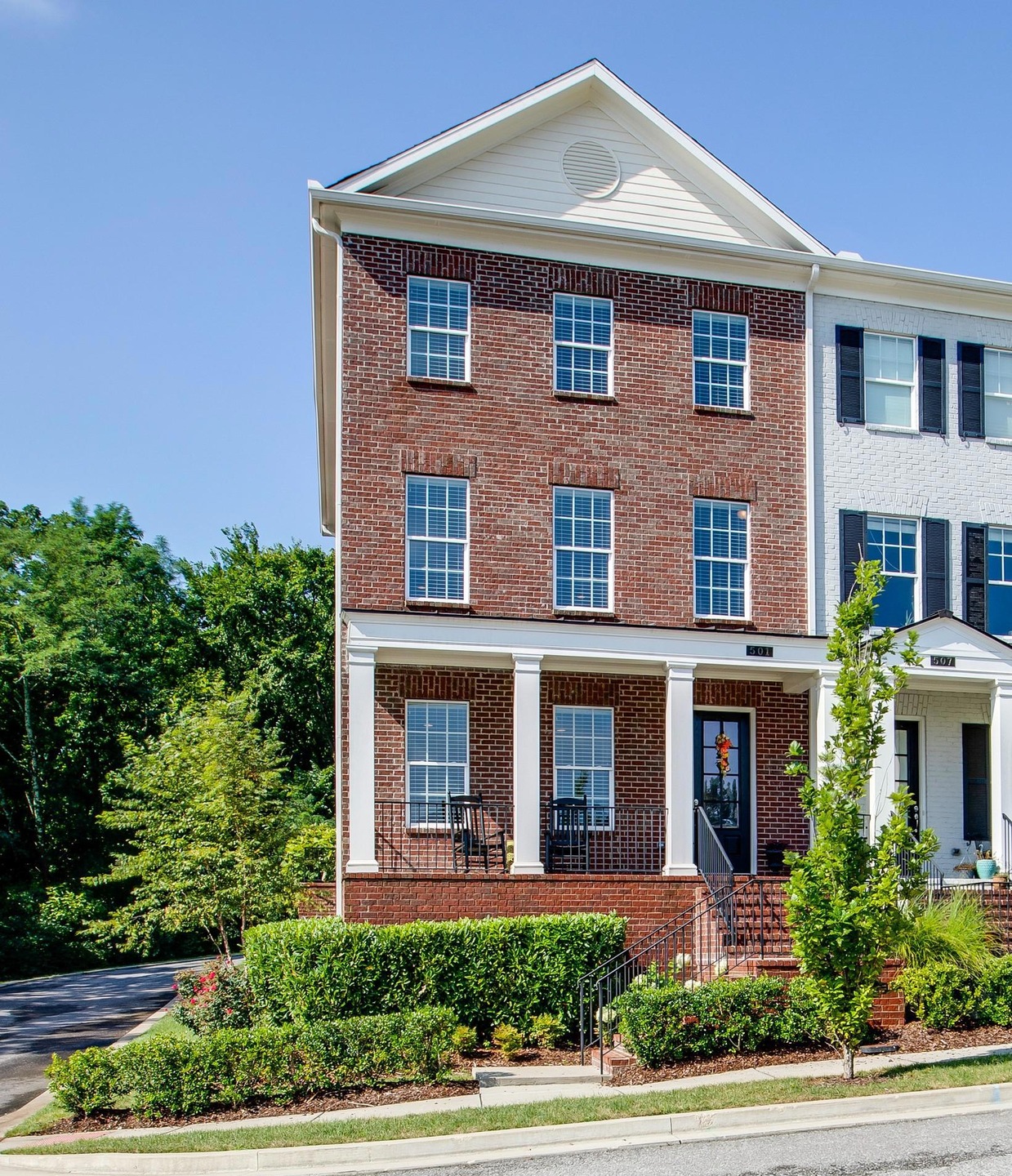 All brick 3 story end unit Townhome with covered front porch and 2 car attached garage off of the back alley.  
