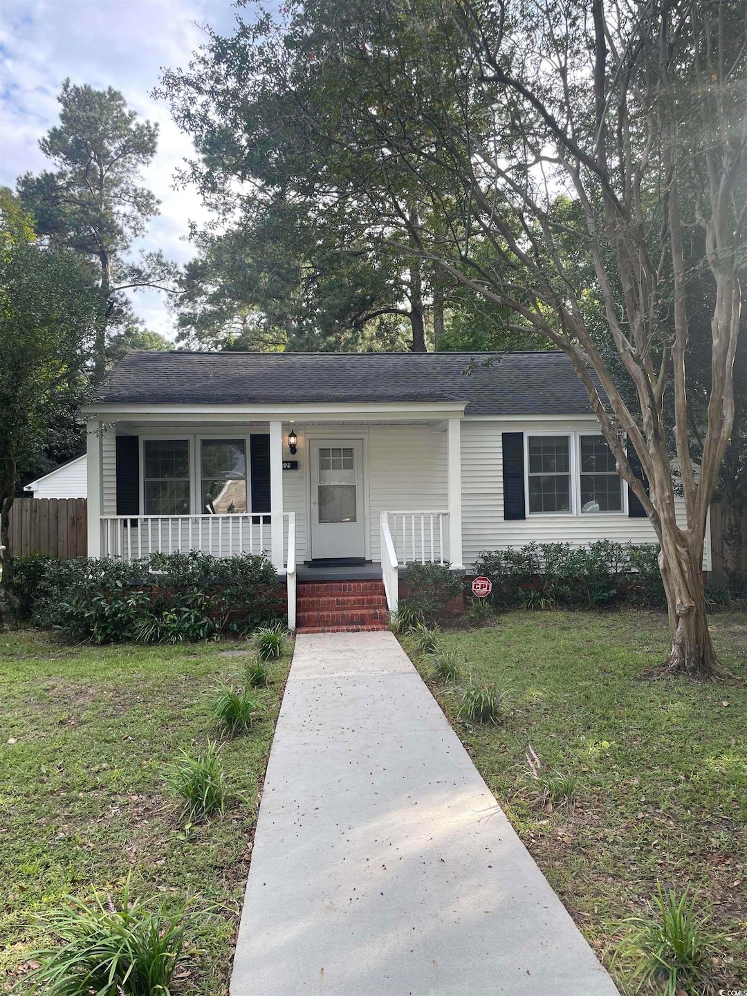 View of front of house featuring a front lawn, a porch, and a shingled roof